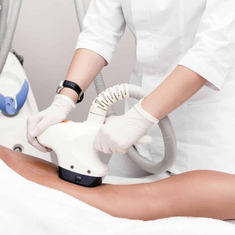 Ultrasound cavitation body contouring treatment. Woman getting anti-cellulite and anti-fat therapy on her leg in beauty salon.